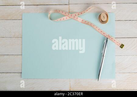 Blank open blue paper with centimeter tape on white wooden table with space for text or business food concept. Concept sport, diet, fitness, healthy e Stock Photo