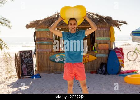 Caucasian man holding surf board on beach Stock Photo