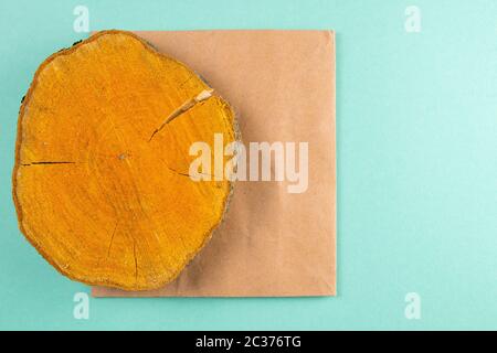 Wooden round board and craft paper on mint background. Stock Photo