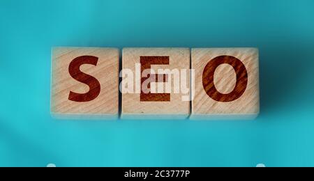 SEO word on wooden blocks with letters, search engine optimization SEO business concept, top view on aquamarine cyan background Stock Photo