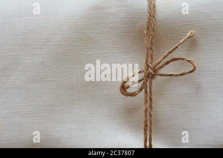 Twine tied in a bow. Close-up. Fabric background Stock Photo