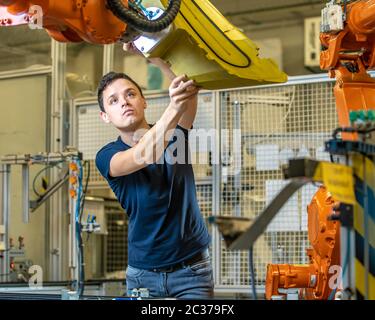 dismantling the robotic arms in the factory when relocating production to another country. Stock Photo