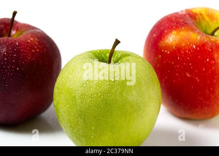 Three apples with water drops. Delicious appetizing beautiful fresh green and red apples on a white background. Stock Photo