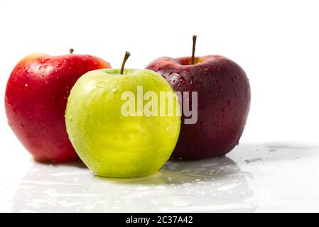Three apples with water drops. Delicious appetizing beautiful fresh green and red apples on a white background. Stock Photo