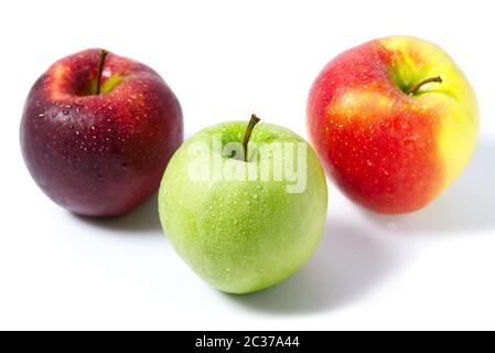 Three apples with water drops. Delicious appetizing beautiful fresh green and red apples on a white background. Stock Photo