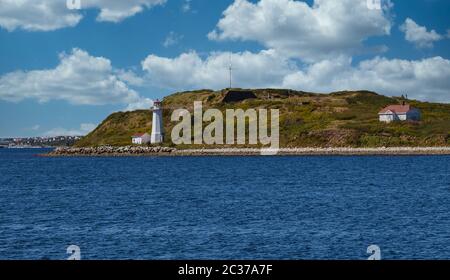 White Lighthouse on shore of green island near Halifax, Nova Scotia Stock Photo