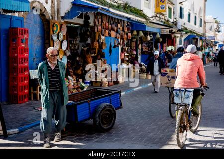 Marrakech, Feb 2019: Busy crowded street in Moroccan medina with traditional stores, souk selling souvenirs. Morocco street in old town with people Stock Photo