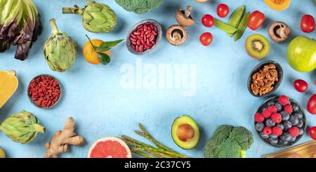 Vegan food panorama, healthy diet background. Fruits, vegetables, nuts, legumes, mushrooms, shot from the top, forming a frame w Stock Photo