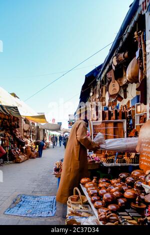 Essaouira, Morocco, Feb 2019: Man vendor selling traditional Moroccan souvenirs made of wood at traditional street market. Moroccan old town medina Stock Photo