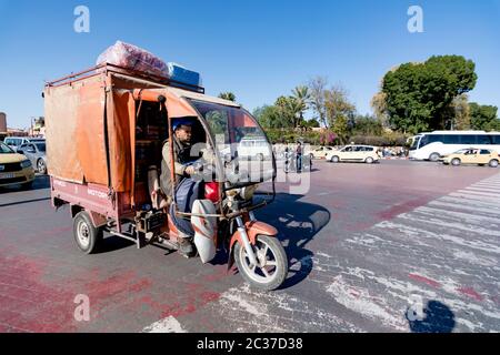 Marrakech, North Africa, Feb 2019: Busy moroccan street full with cars. Muslim man driver in old vehicle transporting, delivering goods. Traffic in Mo Stock Photo