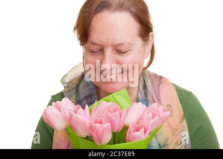 Elderly woman holding a bouquet of colorful pink tulips, smelling and  looking down, isolated on white background. Mothers day, Stock Photo