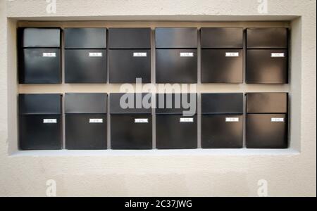 Mailboxes lined up in rows on a wall Stock Photo