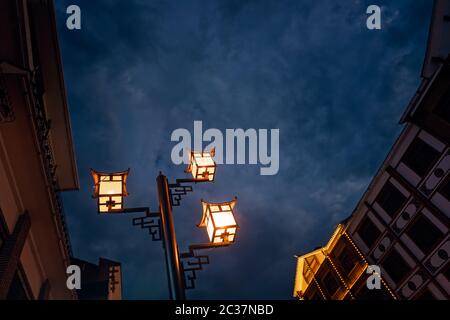 Brightly lit lamppost on the street in Wulingyuan after dusk at night, Hunan Province, China Stock Photo