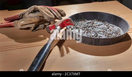 old rusty hammer and construction gloves laid on wooden board in studio Stock Photo