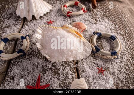 Sea salt crystals in the sea shell on wooden background Stock Photo