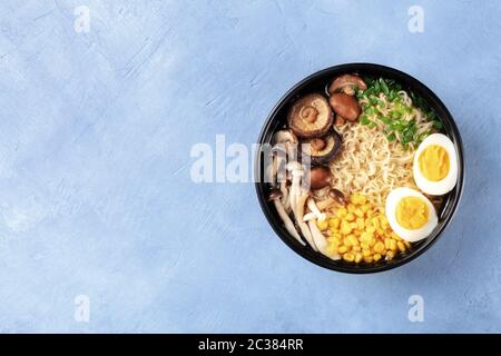 Ramen noodle soup. Soba with eggs, shiitake and enoki mushrooms, sweetcorn and scallions, shot from the top with a place for tex Stock Photo