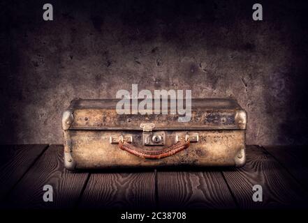Old shabby suitcase on dark background Stock Photo