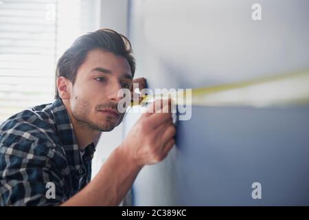 Man taking measure on the blue wall