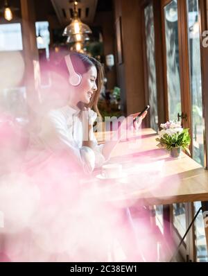 Successful female young adult asian freelancer working in cafe with laptop. Stock Photo