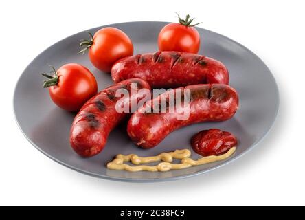 Fried sausages with tomatoes mustard and ketchup on a plate. Isolated on white background. The concept of traditional food. Stock Photo
