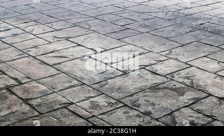 Concrete or cobblestone gray paving slabs or stones for the floor. Pavement in the city. Large gray paving tiles close up Stock Photo