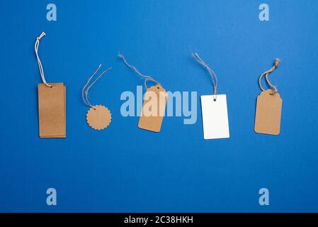 set of paper brown and white blank tags on a rope on a blue background. Vintage flat business template with paper brown tag empty for packaging design Stock Photo