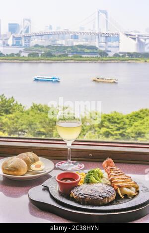 Minced beef and seafood lobster tail with cheese, corn,broccoli,bread on plate and white wine with t Stock Photo