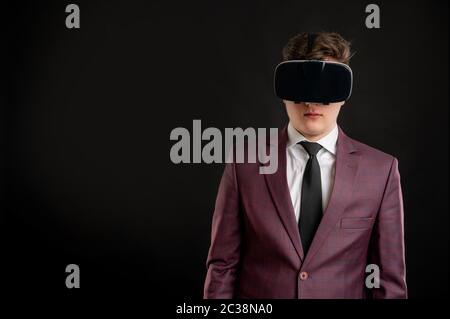 Portrait of engineer architect builder with blond hair wears a yellow safety helmet dressed in burgundy jacket, white shirt and black tie takes notes Stock Photo