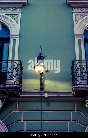 Old-fashioned street lamp attached to a wall between two balconies, Merida, Mexico Stock Photo