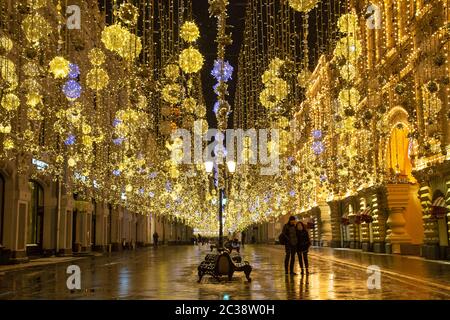 Moscow, Russia, Febrary 12, 2020: Golden colorful rain of Christmas decorations hanging from the sky, on Nikolskaya street next Stock Photo