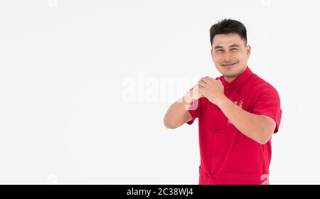A young Asian man who stood happily smiling and bowed to wish everyone a happy, prosperous fortune on Chinese New Year. Stock Photo