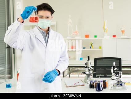An Asian male scientist is experimenting with the search for medicine. In the lab Stock Photo