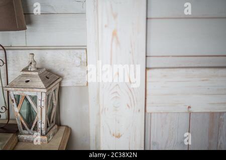 wooden lantern painted white old paint peeling vintage, standing on the table, next to a brown old lamp with a brown shade Stock Photo