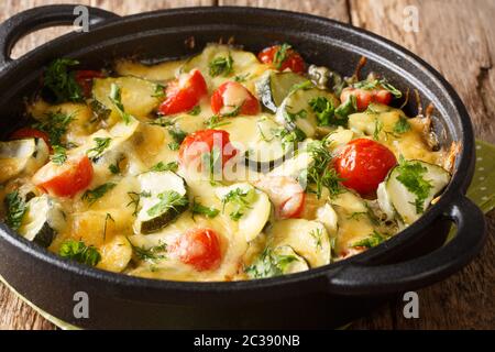 Zucchini summer casserole with cheese and cherry tomatoes close-up in a pan on the table. horizontal Stock Photo