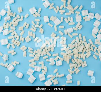 scattered white foam for packaging parcels on a blue background, full frame Stock Photo
