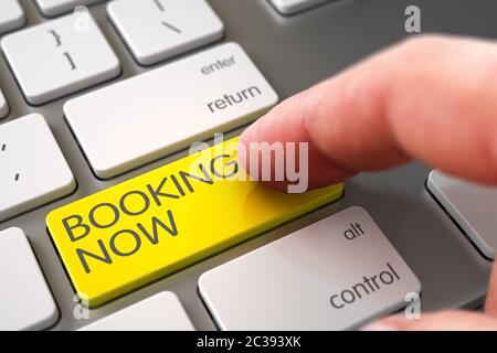 Computer Keyboard with Booking Now Yellow Button. Man Finger Pushing Booking Now Yellow Button on Laptop Keyboard. Booking Now Concept - Metallic Keyb Stock Photo