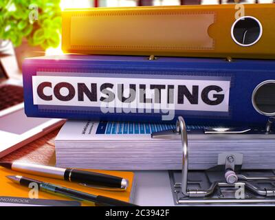Consulting - Blue Ring Binder on Office Desktop with Office Supplies and Modern Laptop. Consulting Business Concept on Blurred Background. Consulting Stock Photo