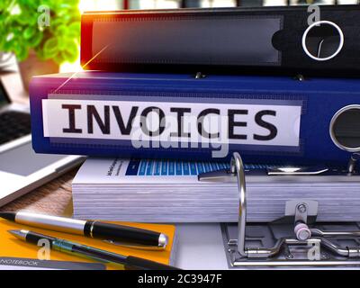 Blue Ring Binder with Inscription Invoices on Background of Working Table with Office Supplies and Laptop. Invoices - Toned Illustration. Invoices Bus Stock Photo