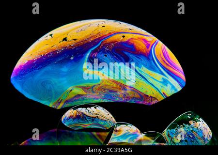 Swirling colourful abstract patterns in bubbles photographed in studio with a black background Stock Photo