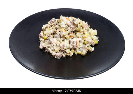 portion of russian Olivier salad on black plate isolated on white background Stock Photo