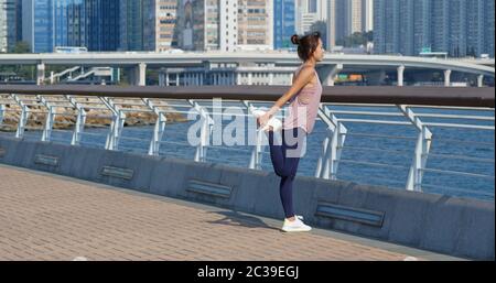 Woman stretch legs before running at outdoor Stock Photo