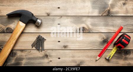 Top view of the hammer and carpenter's work tools on an antique wooden table. Construction industry, do it yourself. Text space. Stock Photo