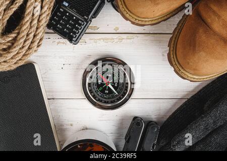Hiking boots with equipment for hiking, cup of tea on wooden board Stock Photo