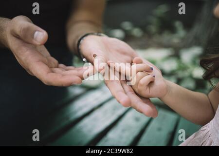 Close-up view of child's and man's hands with ladybug Stock Photo