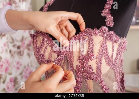 The seamstress sews lace and beads to the pink dress. A woman makes a dress with her own hands in a studio. Small business after coronavirus. A sewing Stock Photo - Alamy The seamstress sews lace and beads to the pink dress. A woman makes a dress with her own hands in a studio. Small business after coronavirus. A sewing Stock Photo - Alamy