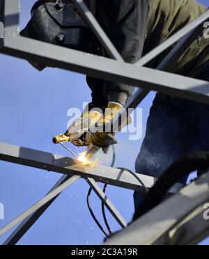 worker welding metal construction on a site. Stock Photo