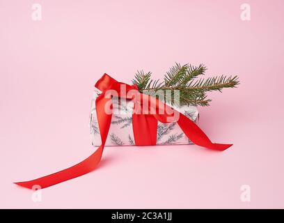 pink wrapped gift boxes and tied with a red bow, pink holiday backdrop Stock Photo