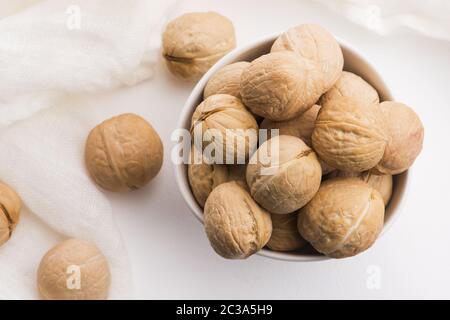 Walnuts in a white ceramic bowl on a white background Stock Photo