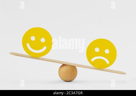 Smiley face and sad face on scale - Concept of sadness as predominant emotion Stock Photo
