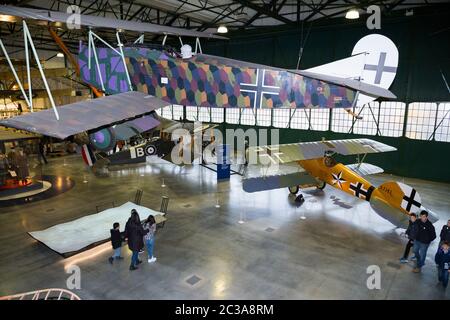 Aerial view of Hangar 2 / H2 The first World war in the air with visitors and tourists looking at the displays. Plane suspended from the ceiling is the Fokker D. VII; a German World War I fighter aircraft. RAF Royal airport Museum, Hendon London UK. (117) Stock Photo